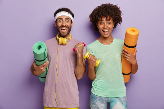 运动锻炼 健身和运动概念快乐的混血夫妇锻炼 举哑铃 抱着垫子 在健身房训练运动的家庭一起去运动健康的生活方式非洲紫色二头肌