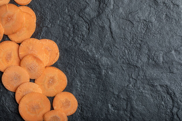新鲜新鲜生胡萝卜片黑色背景高品质照片有机圈素食