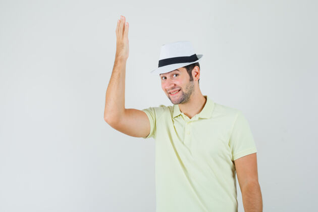 男性一个穿着t恤 戴着帽子的年轻人举起手臂 看上去很高兴手臂英俊模特