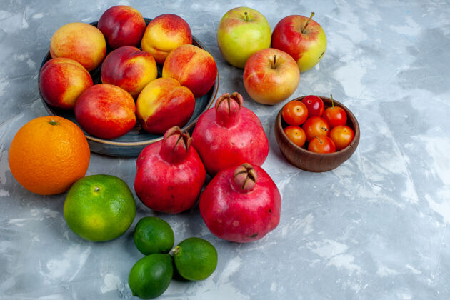 新鲜半顶视图新鲜桃子美味的夏季水果配橘子和苹果在浅白的桌子上新鲜水果醇厚的维生素成熟的树醇厚水果维生素