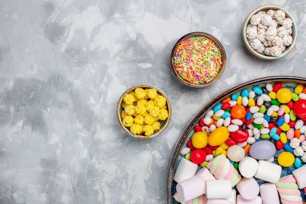 桌子顶视图糖果组成不同颜色的糖果棉花糖在白色办公桌上糖果邦邦甜茶棉花糖顶部不同
