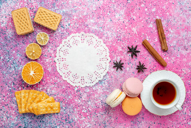 生的在粉红色的桌子上可以俯瞰一杯茶 里面有法国马卡龙和饼干蛋糕甜食水疗