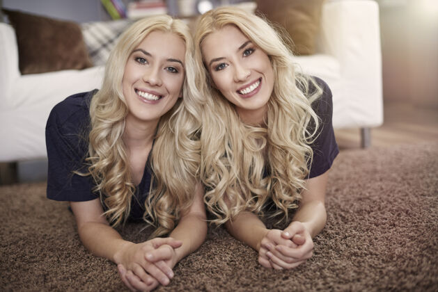 当代美丽的金发双胞胎的画像卷发享受肖像