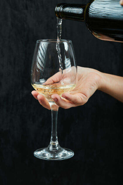 葡萄把白葡萄酒倒在酒杯的深色表面上味道手饮料