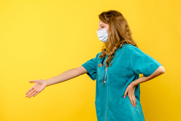 黄色正面图戴面具的女医生在黄色空间握手前面医学女士