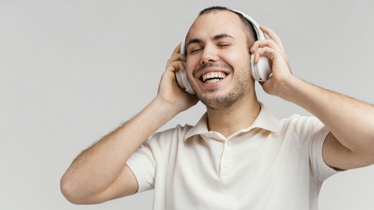 休闲戴着耳机的男人在笑男人科技室内