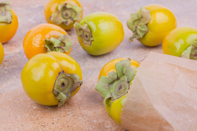 生物黄色的李子枣放在粉红色的大理石上极简甜味可口