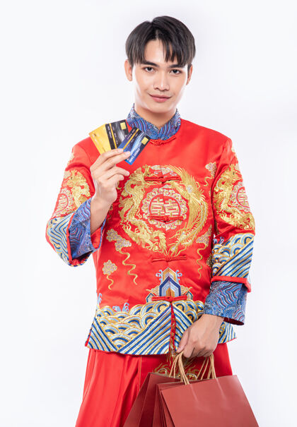 欢呼穿旗袍套装的男人在中国新年用信用卡可以得到很多东西传统服装团聚女孩