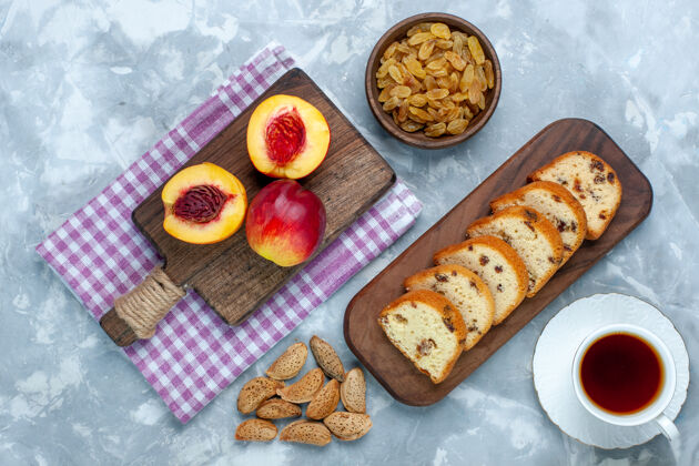 美味在浅白色的桌子上 可以俯瞰新鲜的桃子 香醇可口的水果 蛋糕和葡萄干面包水果醇香