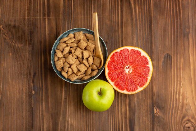 零食俯瞰棕色木制书桌上的葡萄柚苹果小饼干健康木头维生素