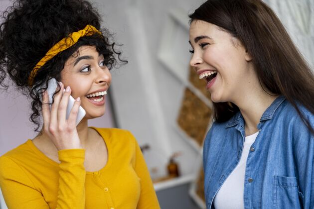 微笑两个快乐的女人在电话里微笑着交谈全球积极乐观