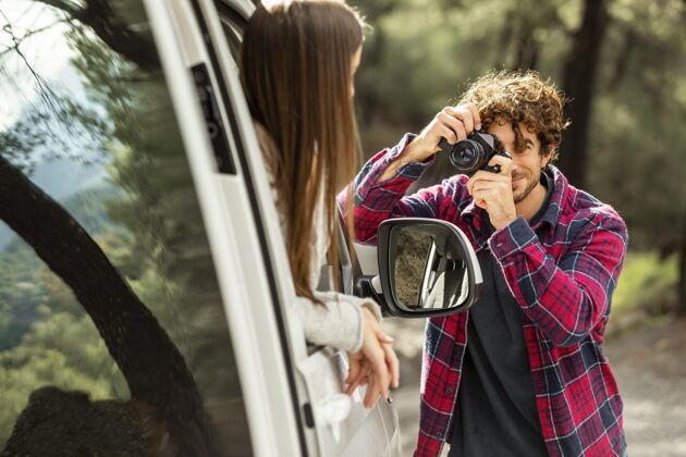 远足男朋友在路上给车里的女朋友拍照旅居人冒险