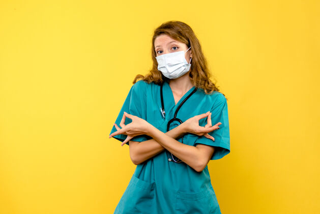健康正面图黄色地板上戴着面罩的女医生情感医院医护人员专业前面微笑