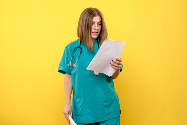 实验室外套前视图黄色空间上的女医生正在阅读文件黄色疾病医学