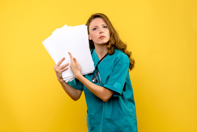 看正面图年轻女医生拿着文件在黄色空间女人持有病毒