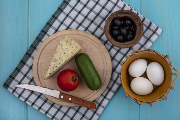 食物顶视图黑橄榄奶酪黄瓜番茄和鸡蛋在一个格子毛巾在一个绿松石背景橄榄吃毛巾