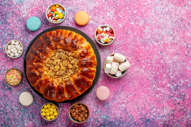 糖顶视图五颜六色的法国马卡龙小美味蛋糕与糖果在粉红色的桌子糖烤饼干饼干蛋糕派饼干小蛋糕