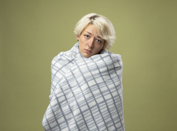 不健病的不健康的女人 短发感觉不舒服 裹在毯子里 站在轻质的墙壁上 看起来像患了流感头发痛苦女人