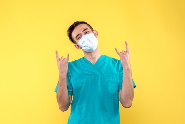 衬衫黄色地板上戴口罩的男医生的正面图病毒健康病毒-医疗快乐男性医生医疗