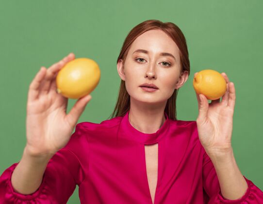 饮食美丽的红发女人摆着水果的姿势肖像水果美丽