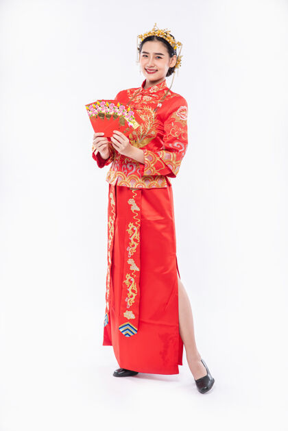 文化穿旗袍西服黑鞋的女人很高兴在春节收到老板的礼金中国新年微笑红包