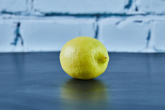 提神整个多汁的黄色柠檬在蓝色的表面水果热带维生素