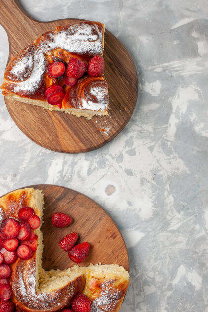 石榴俯瞰美味的草莓派烤和美味的甜点上的白色办公桌派饼干糖饼干甜蛋糕顶部生的浆果