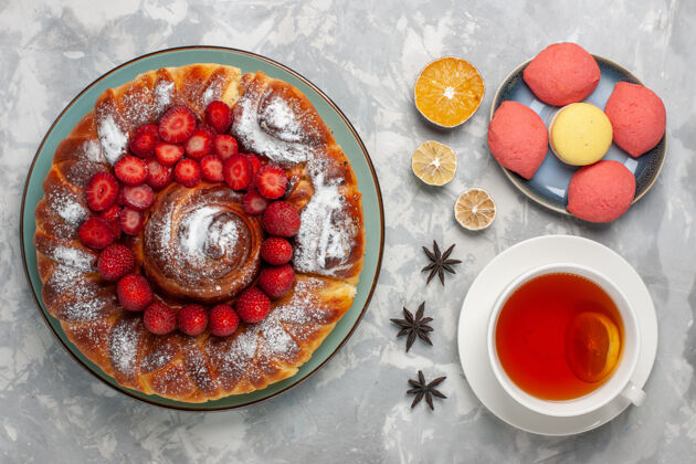 烘焙俯瞰美味的草莓派配上小蛋糕和一杯白茶蛋糕派饼干甜甜的甜茶烤农产品蛋糕顶部