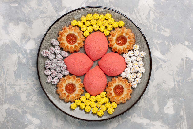 盘子顶部看粉红色蛋糕和糖果和饼干在盘子里的白色表面甜饼饼干茶饼饼干糖果可食用的水果新鲜的