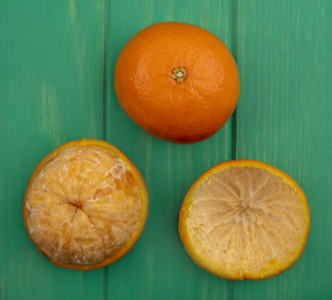 五颜六色绿色背景上带去皮的橙色顶视图绿色果皮水果