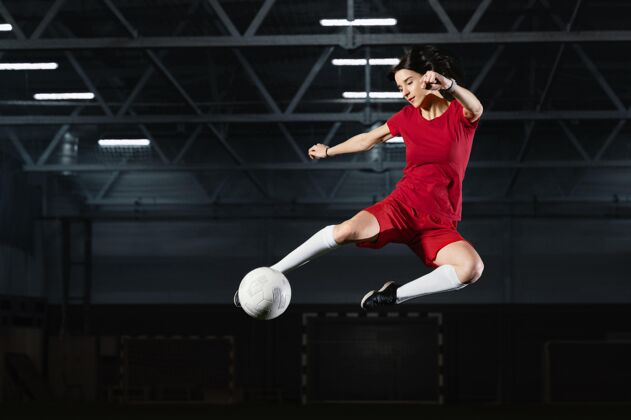 女子女人跳着去踢球踢跳跃足球制服