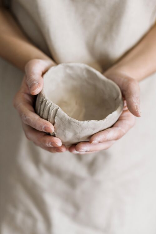 粘土拿着自己做的陶器的女人艺术家陶工职业