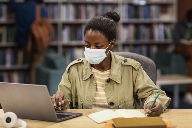 学习戴着口罩的学生在图书馆社区大学妇女