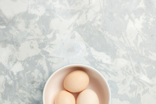 早餐顶视图生全蛋内浅白背景上的小盘子生食早餐早餐照片早上蛋壳浅白色少量
