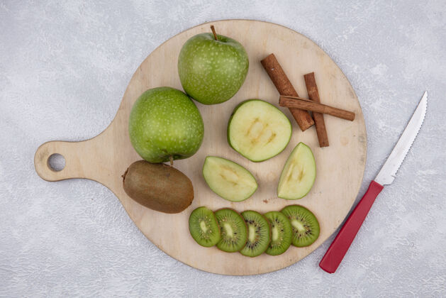 切片俯瞰绿色苹果与猕猴桃和肉桂片的立场与刀上的白色背景肉桂白色观点