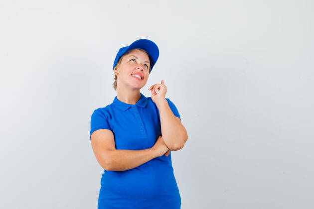蓝色一个穿着蓝色t恤的成熟女人抬起手指 看起来充满希望自信活跃女人