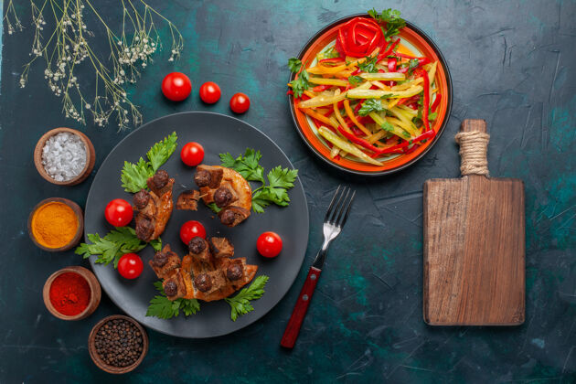 蔬菜俯视图炸肉片与切片蔬菜沙拉和调味料对深蓝色桌蔬菜食品肉类健康餐沙拉晚餐盘子