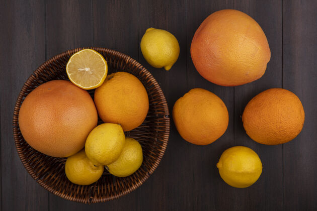 顶部顶视图柠檬与橘子和葡萄柚与篮子木制背景食物柑橘新鲜