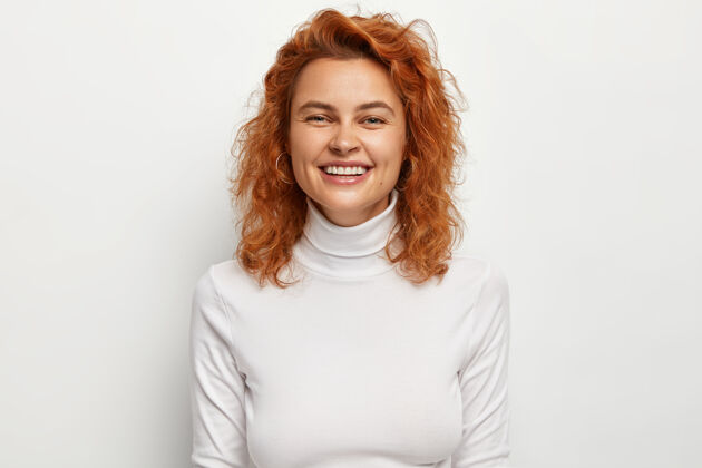 积极正面红发女人的半身镜头有着真诚的牙齿微笑套头衫乐观卷曲