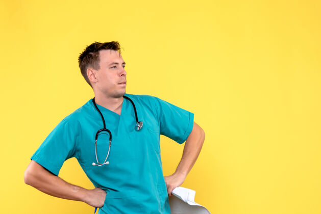 男性浅黄色墙壁上的男医生的正视图人医生听诊器