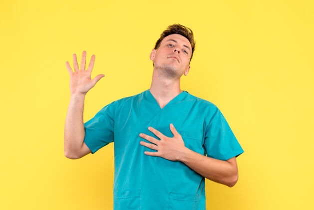 男医生男性医生在黄色墙壁上展示手掌的正面视图人显示医院