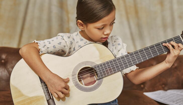 女孩小女孩在家学吉他表演艺术家音乐家