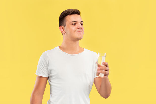 表情黄色工作室背景上的白人青年半身肖像穿着衬衫的漂亮男模人类情感的概念 面部表情 销售 广告享受纯净水事业专业衬衫