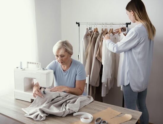 缝纫工作室里有两个女裁缝在一起工作服装女装服装