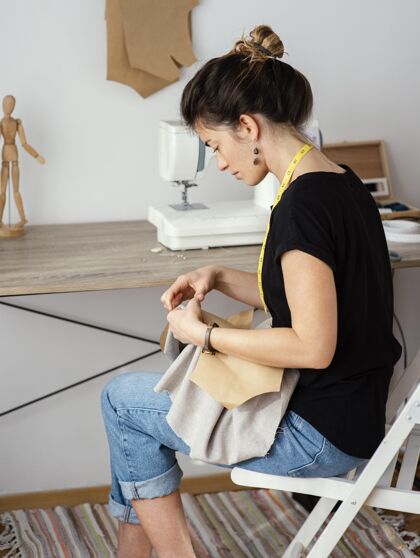 缝纫机女裁缝在工作室工作的侧视图裁缝裁缝针线活
