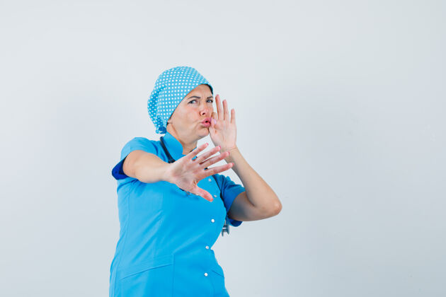 诊断女医生表现出停止的姿态 嘴巴闭上拉链 穿着蓝色制服 看起来很害怕 前视图护士职员手势