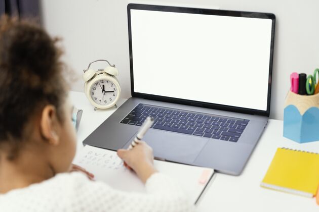 在线高角度的小女孩在家上网上学时带着笔记本电脑学习孩子班级