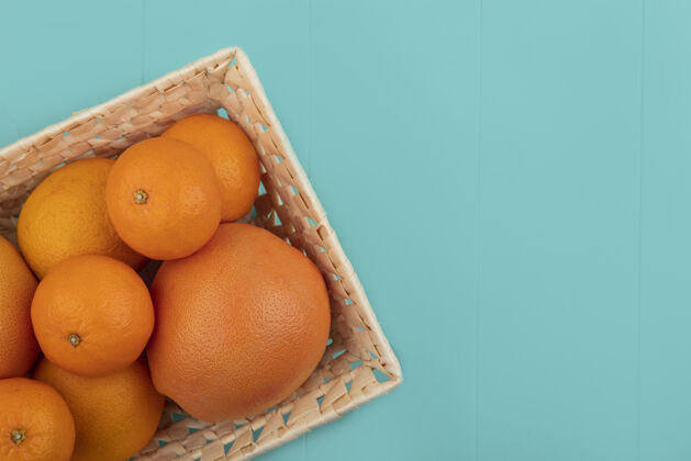 绿松石顶视图复制空间橙子和葡萄柚在一个蓝绿色的背景篮子视图篮子彩色