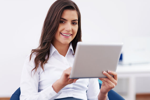 触摸板微笑的女商人使用数字平板电脑数字平板电脑连接上班族