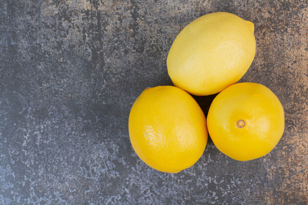 酸三个新鲜的柠檬放在大理石空间里柠檬美味多汁